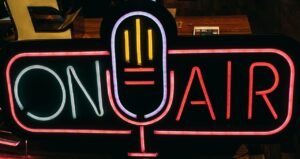 Bright neon 'On Air' sign glowing in a dark studio, perfect for broadcasting themes.